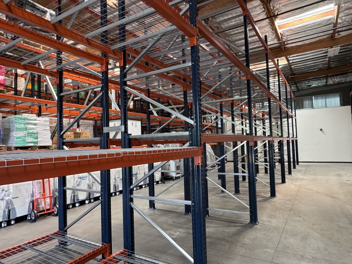 Selective pallet rack beams and wire decking along a rack face